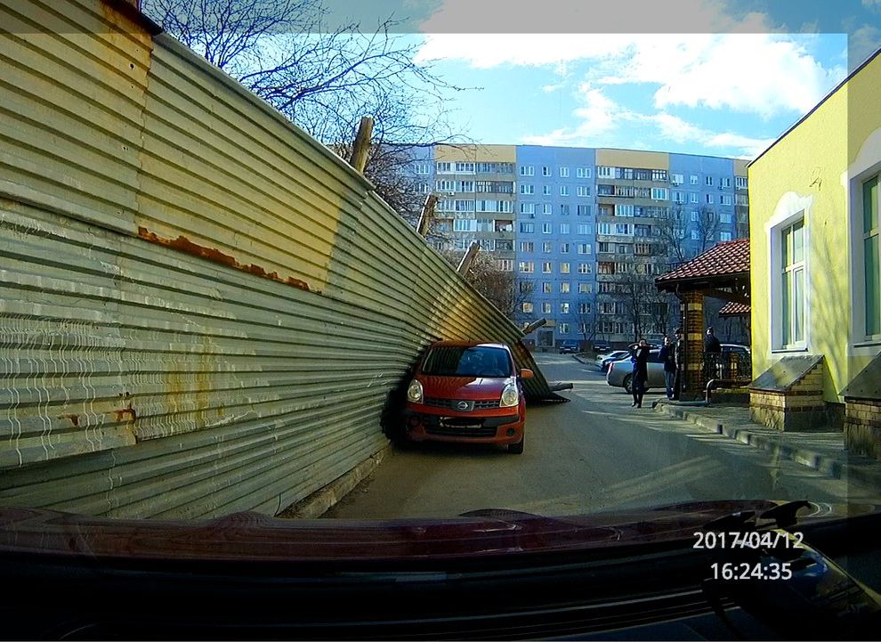 Фото: на улице Новоселов забор рухнул на припаркованный автомобиль