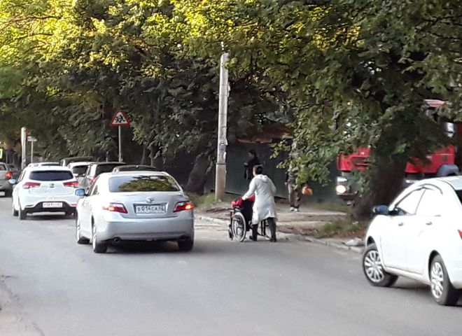 В Рязани засняли женщину, везущую инвалидную коляску по проезжей части