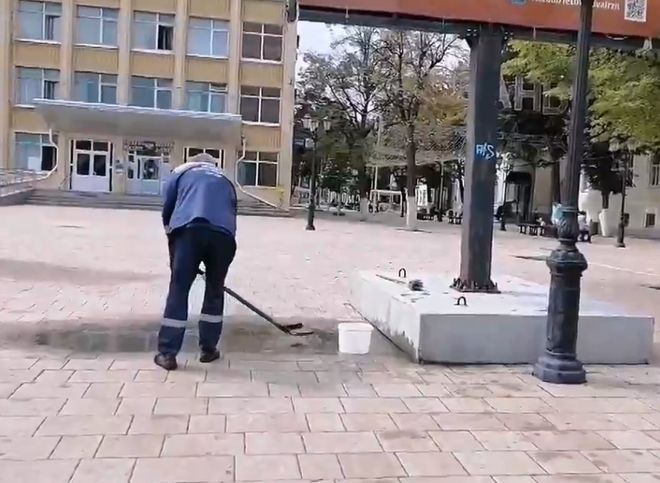 На улице Почтовой засняли мужчину, вычерпывающего лопатой воду из лужи