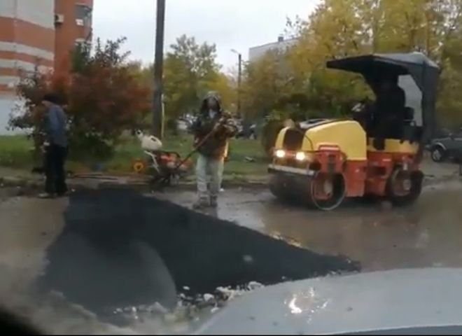 Видео: на улице Зубковой кладут асфальт в лужу во время дождя