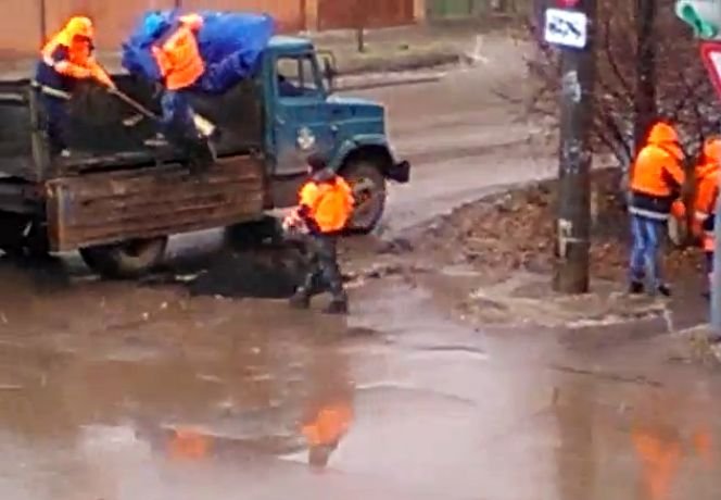 На улице Островского в разгар снегопада укладывают асфальт