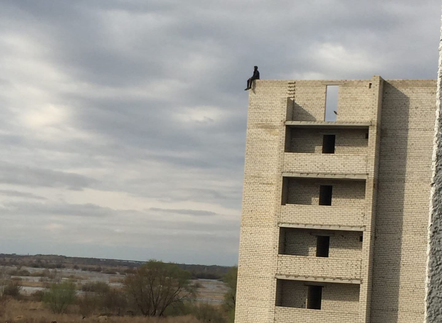 На крыше строящейся рязанской многоэтажки засняли подростка, сидящего на краю