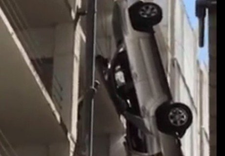 Автомобиль вылетел с 9-го этажа и повис на проводах  (видео)