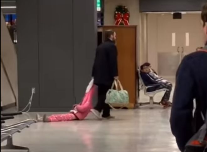 В США мужчина протащил дочь по аэропорту за капюшон (видео)